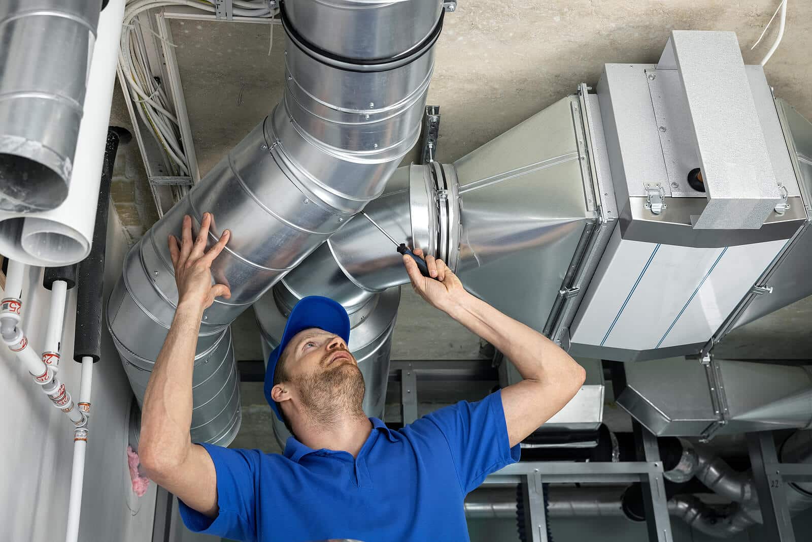 HVAC technician inspecting and repairing air ducts in Visalia