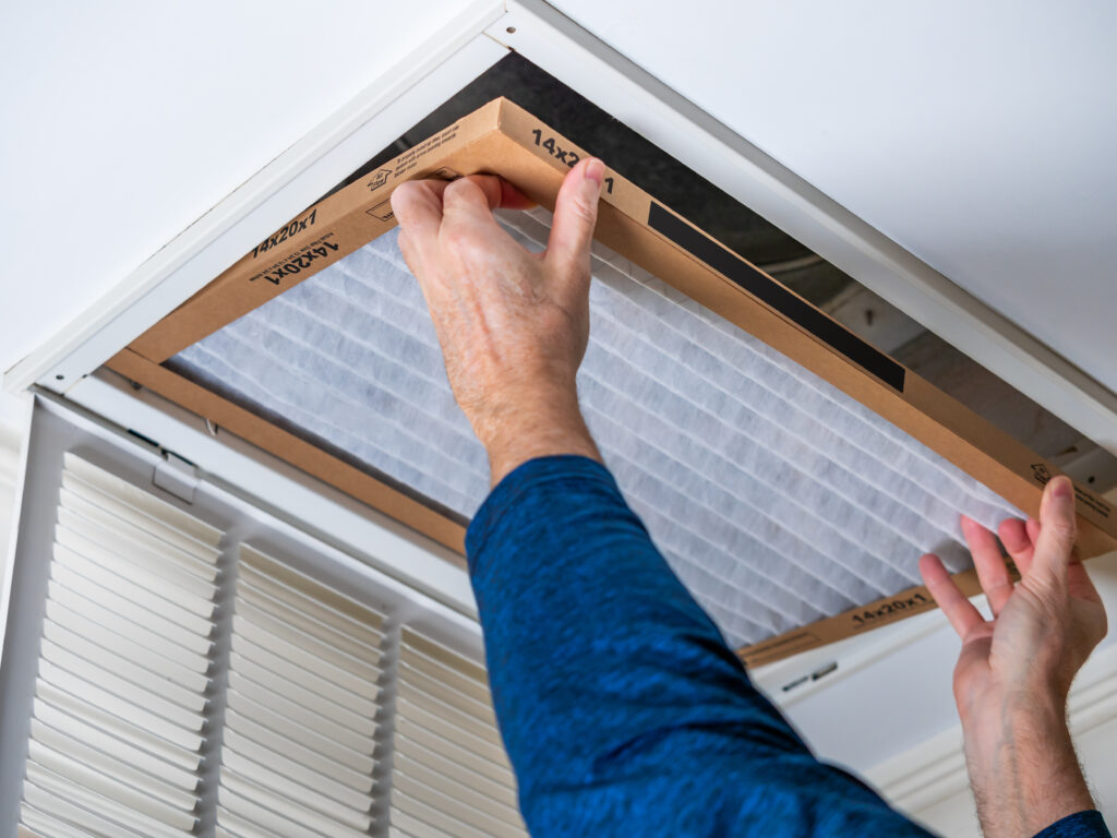 HVAC technician replacing a home air filter in Visalia